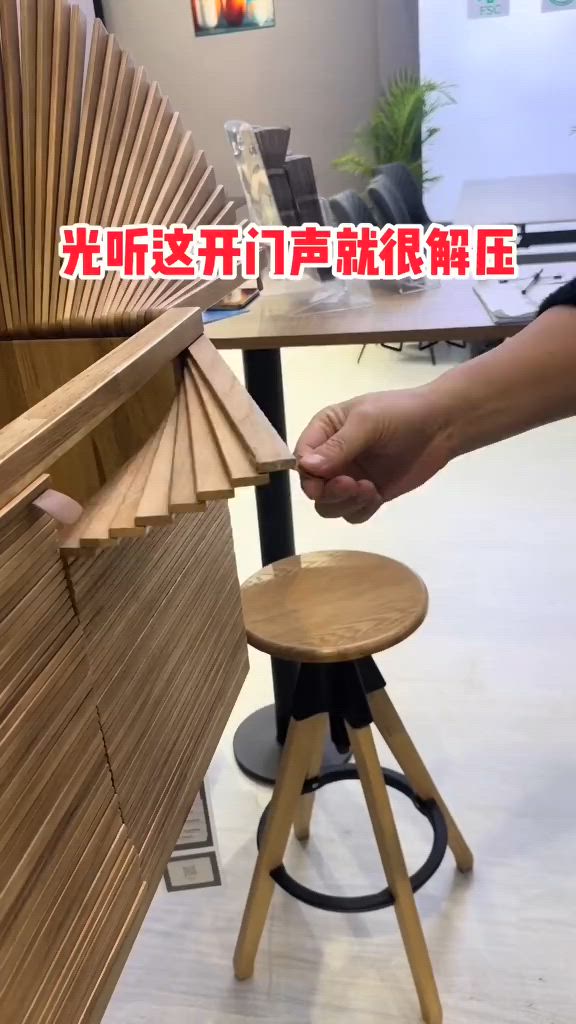 This may contain: a person is holding a wooden fan in front of a table with stools on it