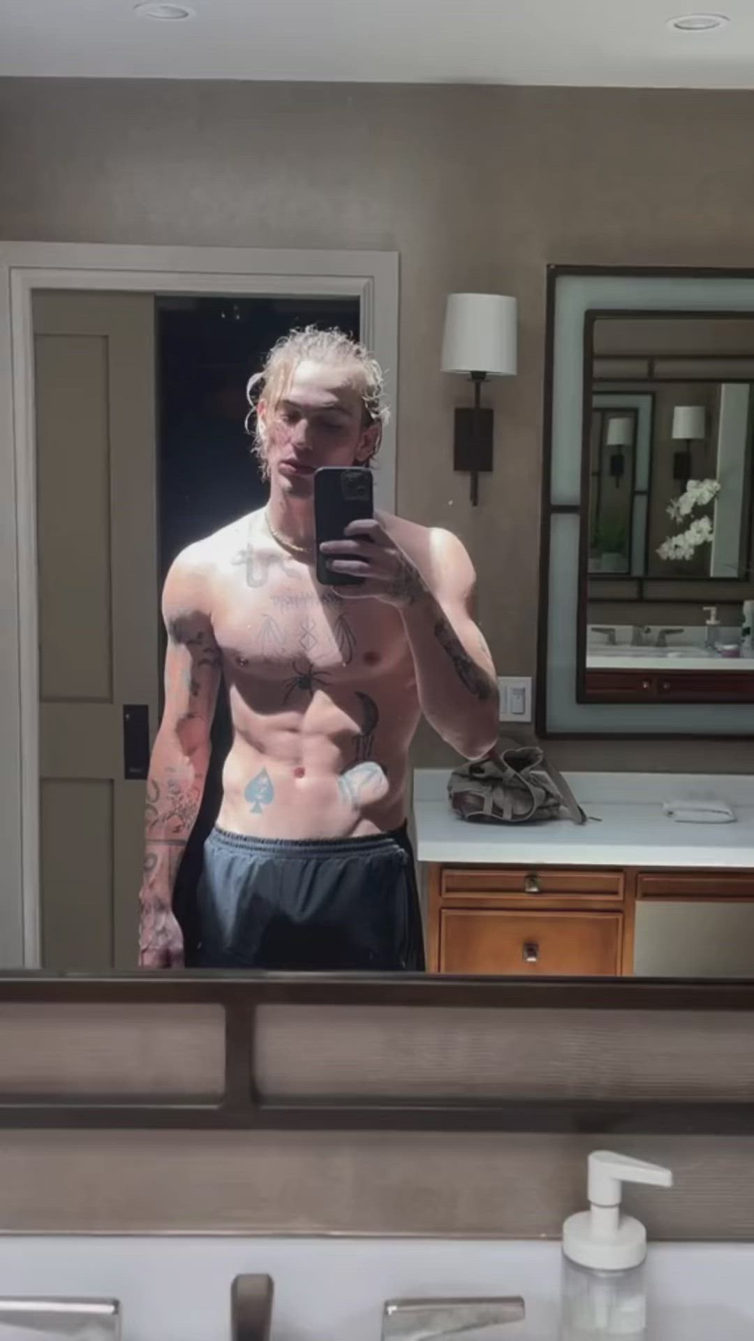 This may contain: a shirtless man taking a selfie in the mirror with his cell phone,