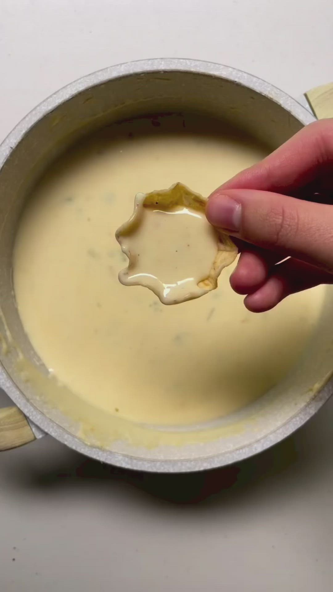 This may contain: a person dipping something in a bowl with a spoon