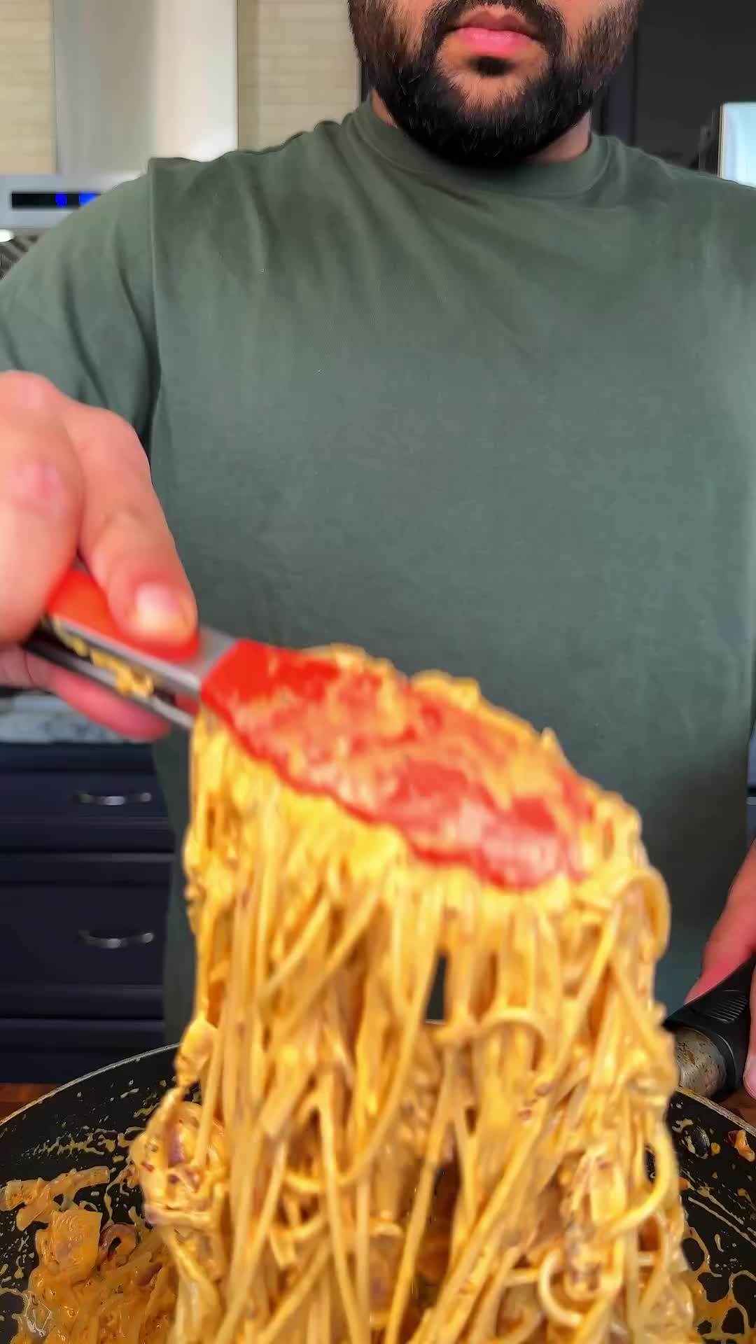 This may contain: a man holding a fork with some noodles on it