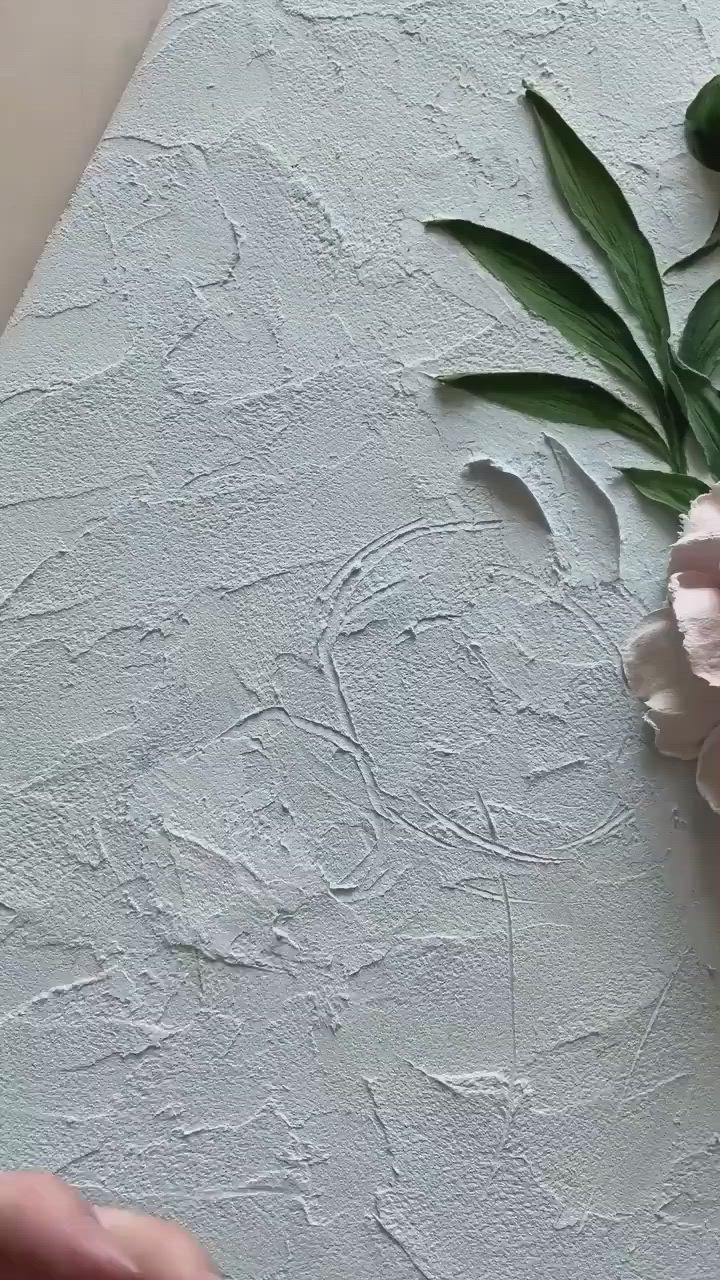 This may contain: someone is painting flowers with white paint on the wall