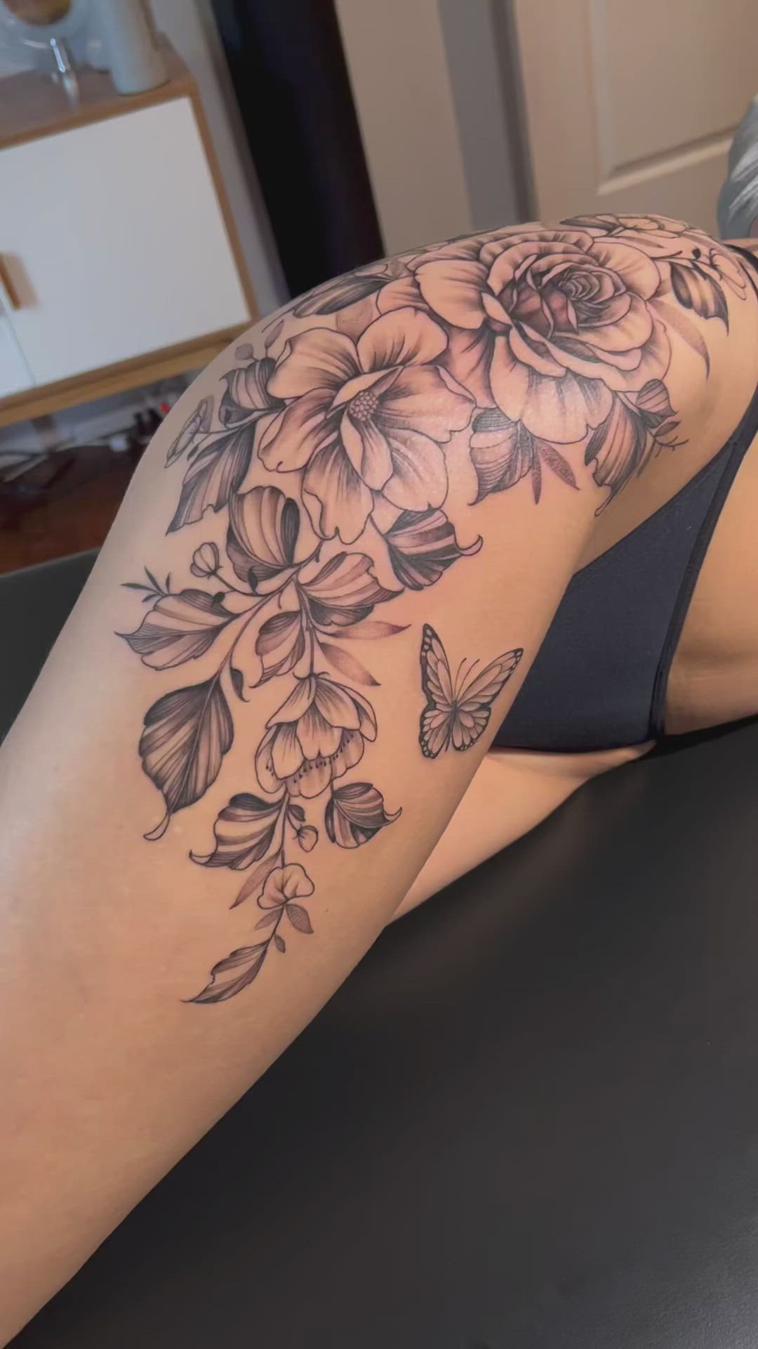 This may contain: a woman's thigh with flowers and butterflies on it