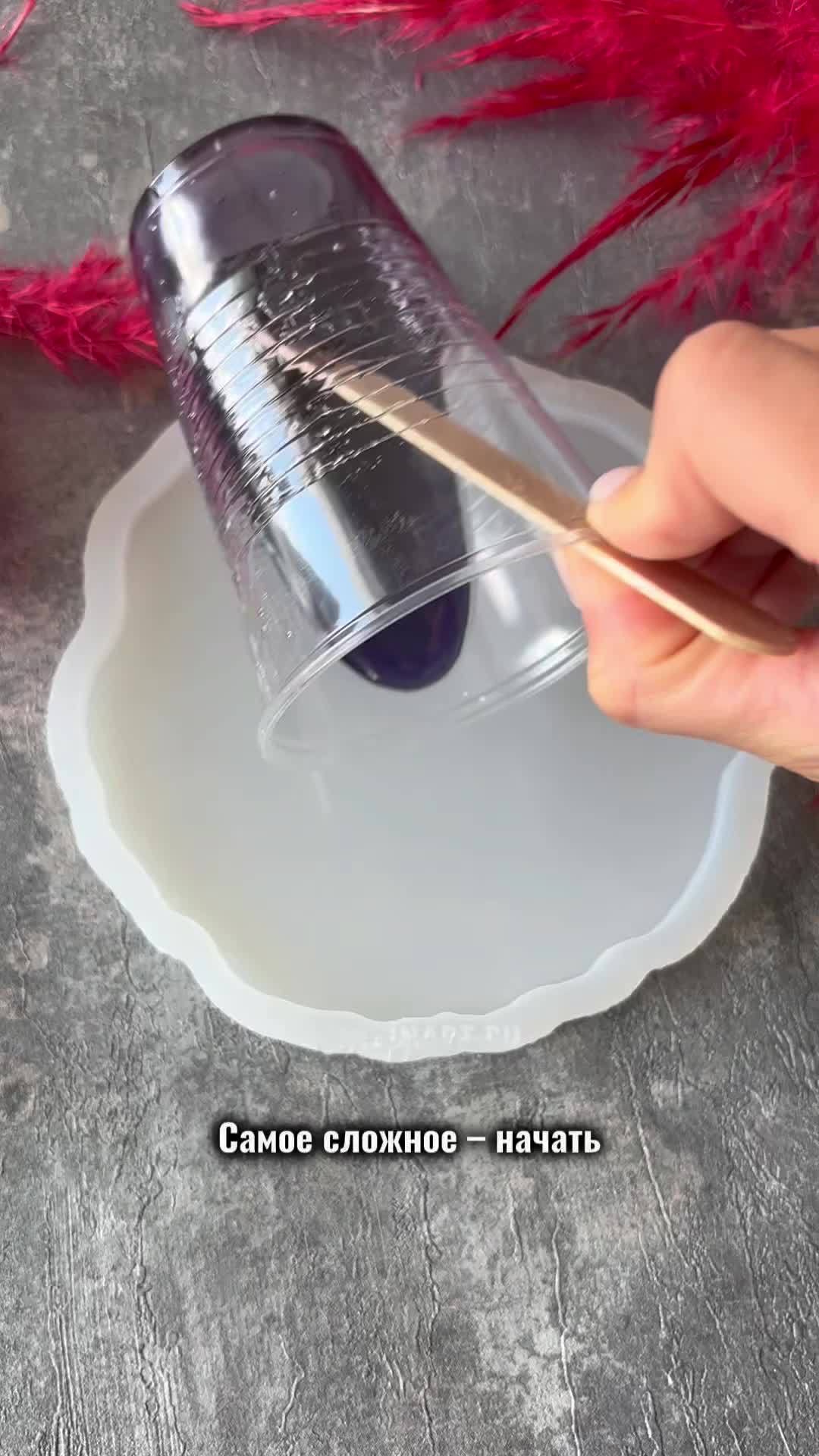 This may contain: a hand holding a purple glass plate next to some flowers and candles on a table