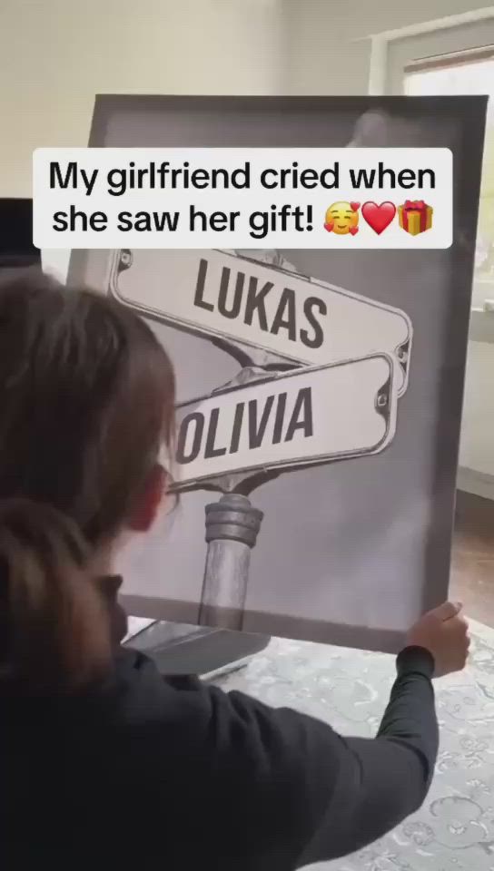 This may contain: a woman holding up a sign with the words luka and ollivia on it