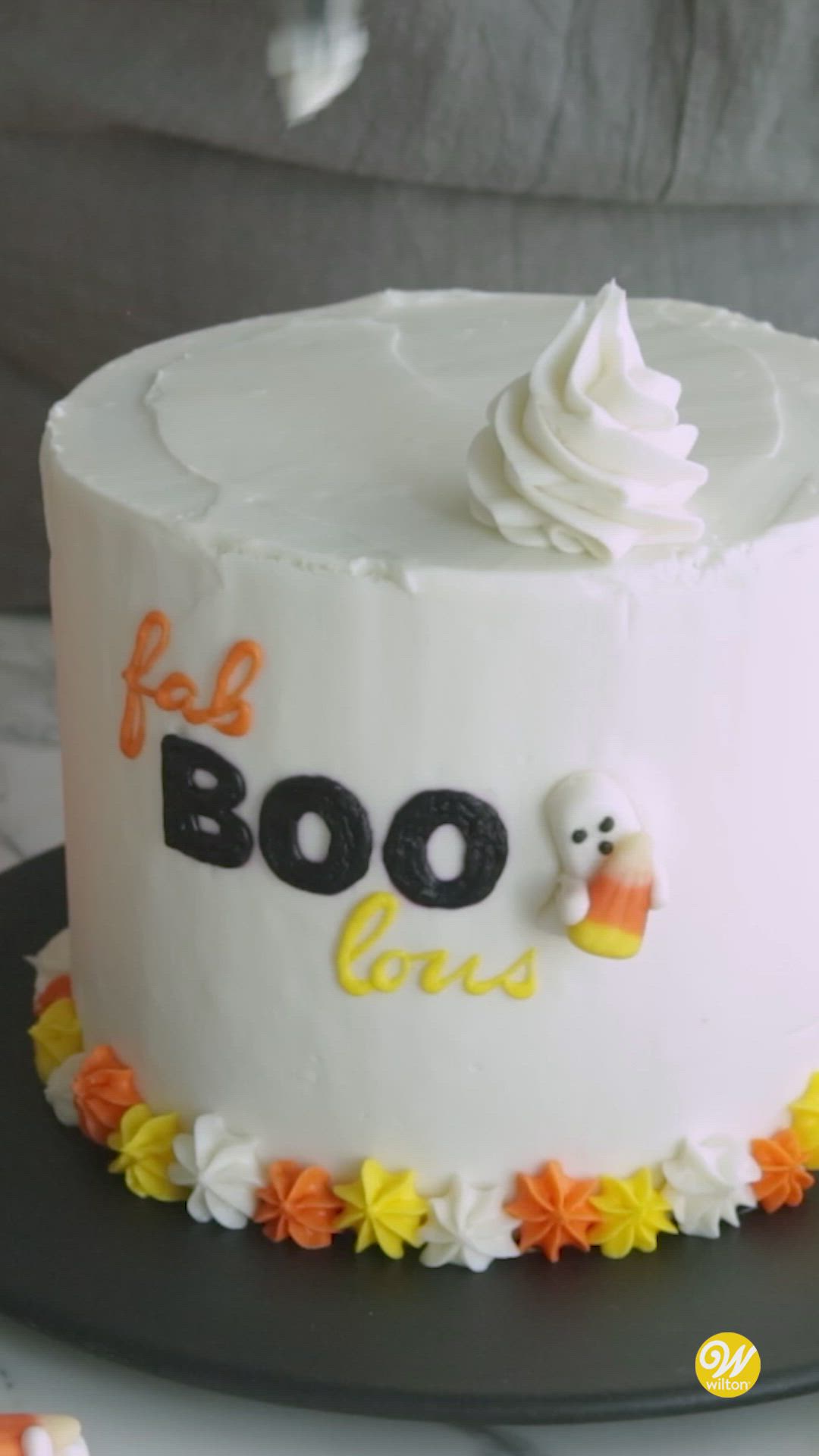 This may contain: a white cake with frosting and decorations on it that says boo - lous