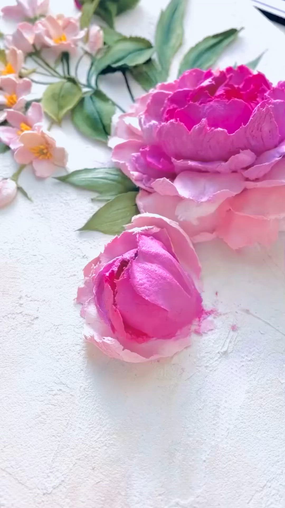 This may contain: some pink flowers are sitting on a table with green leaves and watercolor pencils