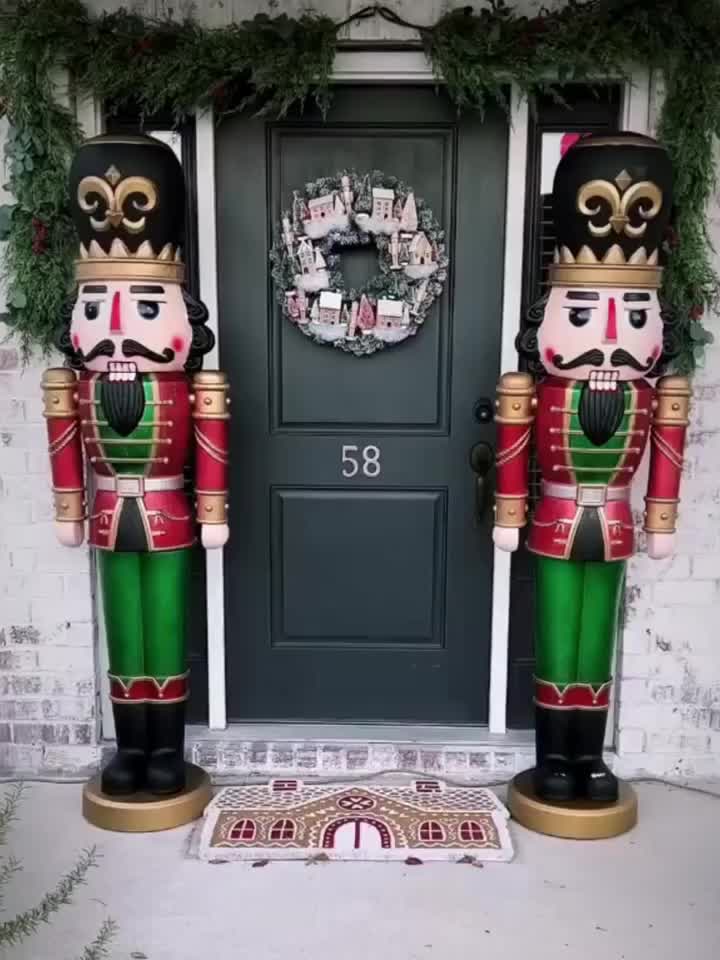 This may contain: two large nutcrackers are standing in front of a door with wreath on it