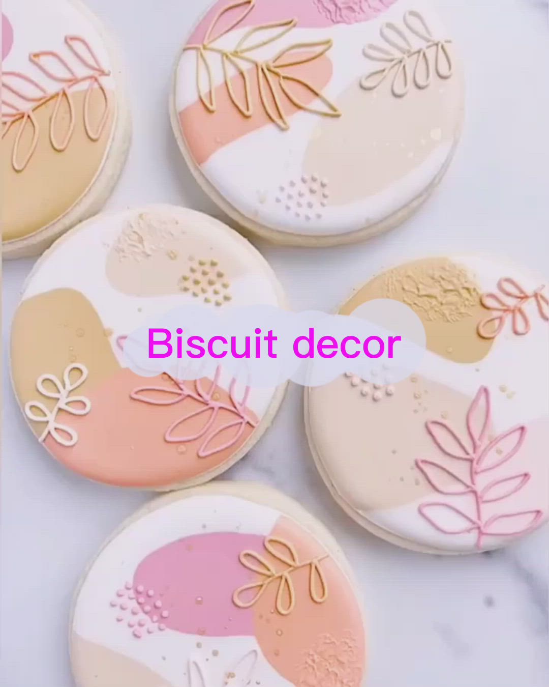 This may contain: four decorated cookies sitting on top of a white table next to a pink and gold plate