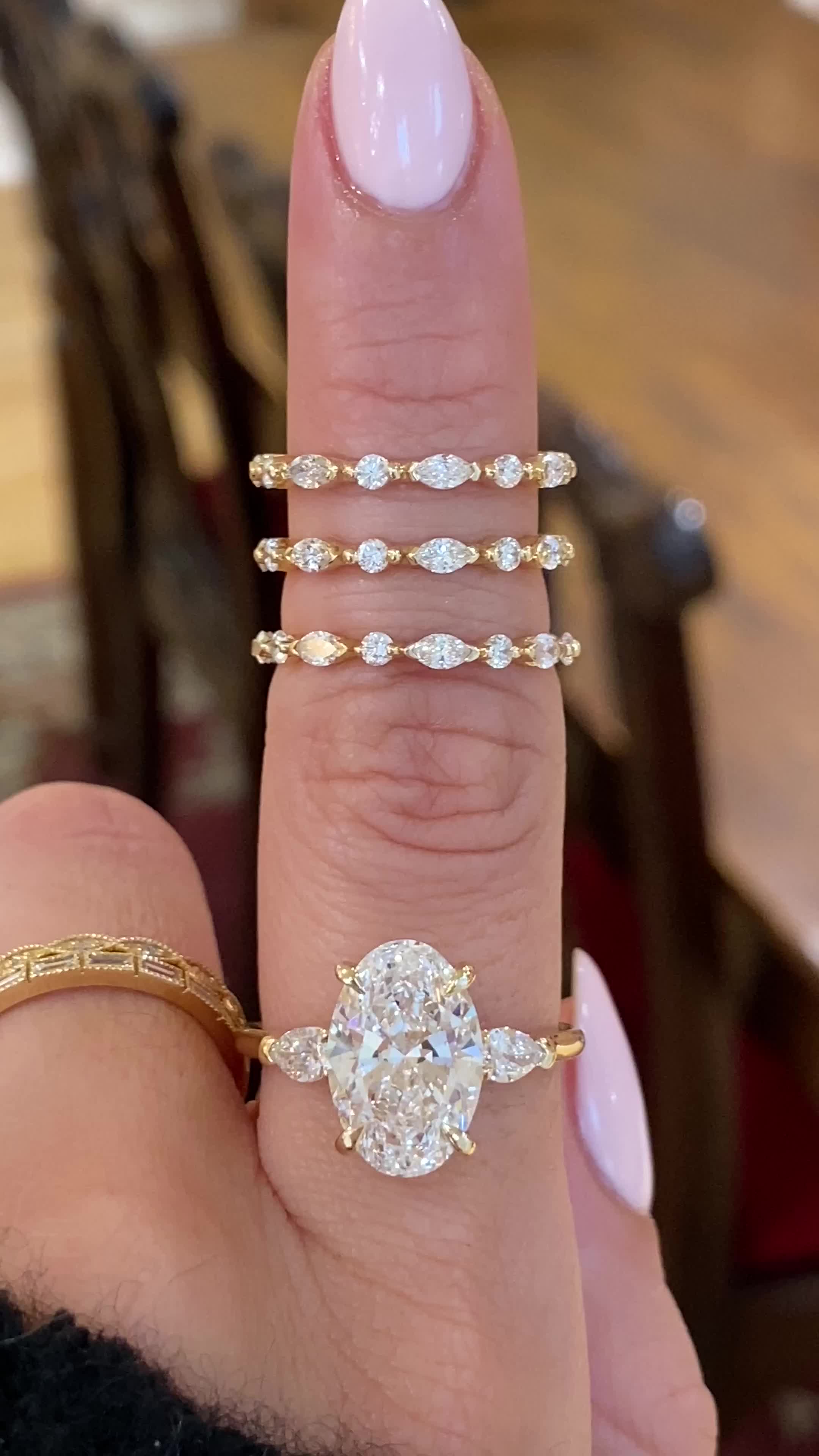 This may contain: a close up of a person's hand with three rings on their fingers and one ring