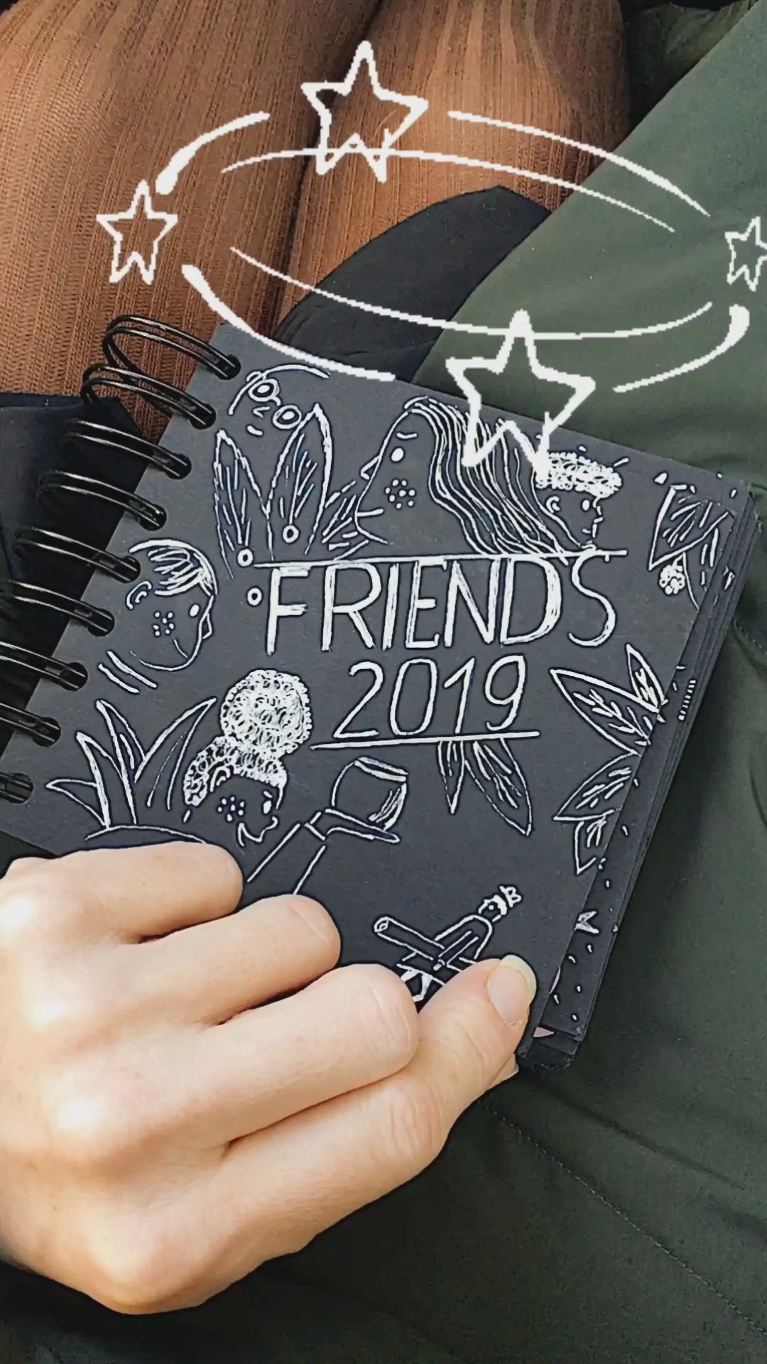 This may contain: a person holding a notebook with the words friend's 2019 written on it