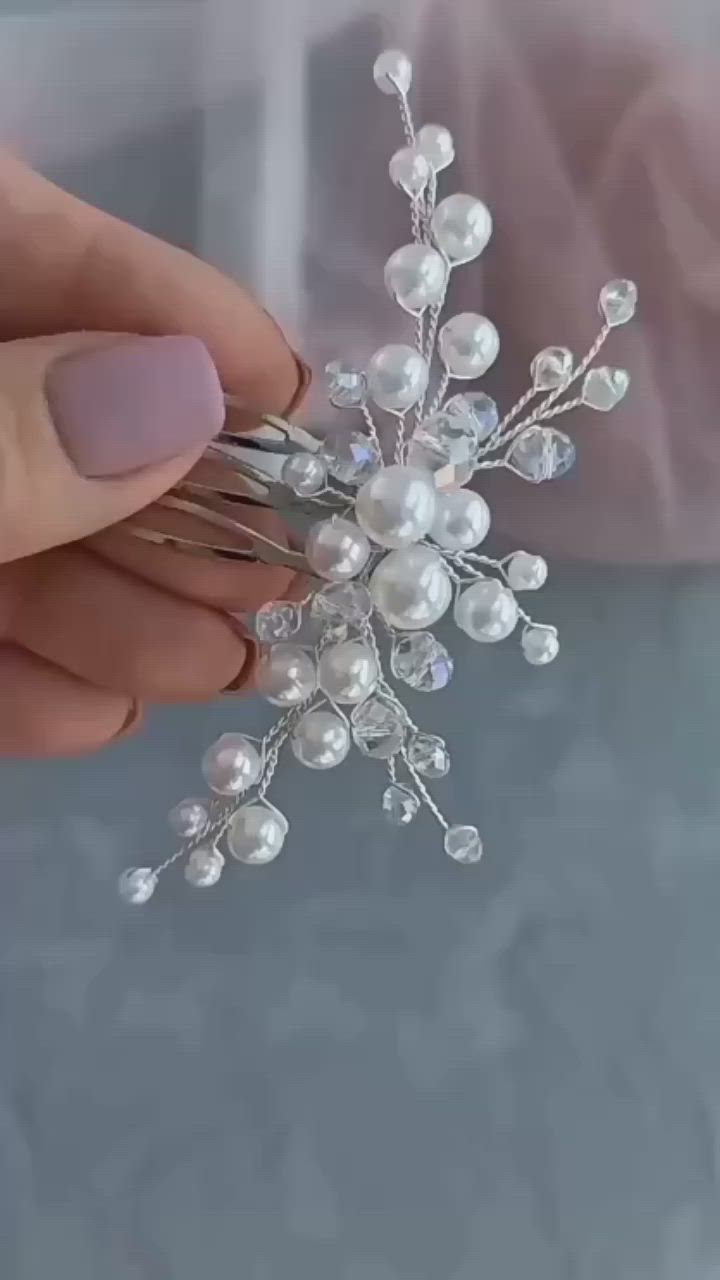 This may contain: a person holding a crystal and pearl snowflake