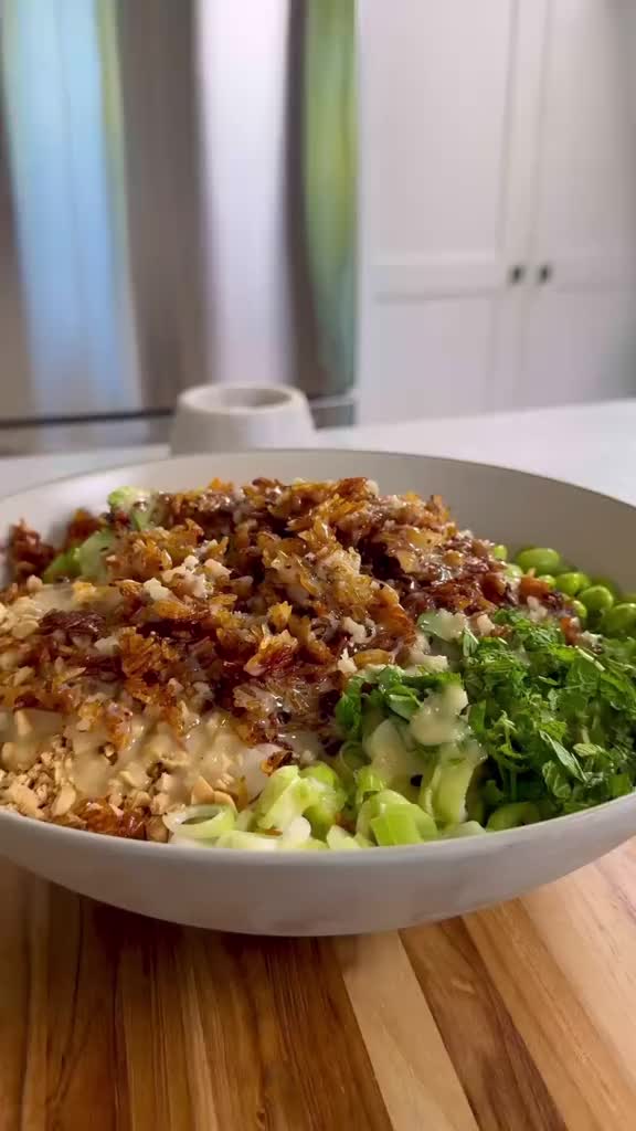 This may contain: a white bowl filled with food on top of a wooden table