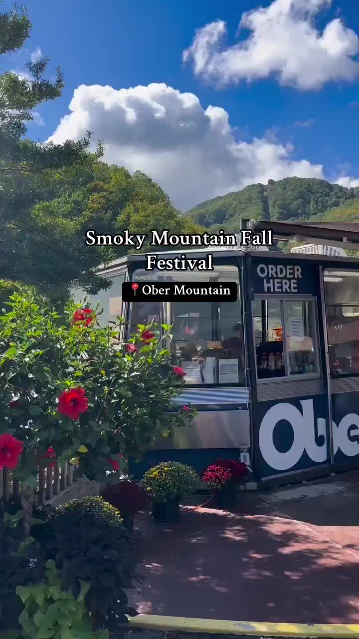 This may contain: an advertisement for the smokey mountain festival on display in front of flowers and trees