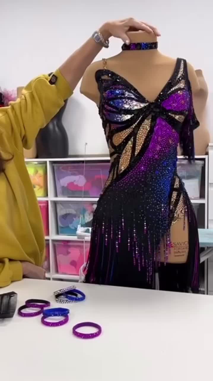 This may contain: a woman is working on a dress in front of a mannequin