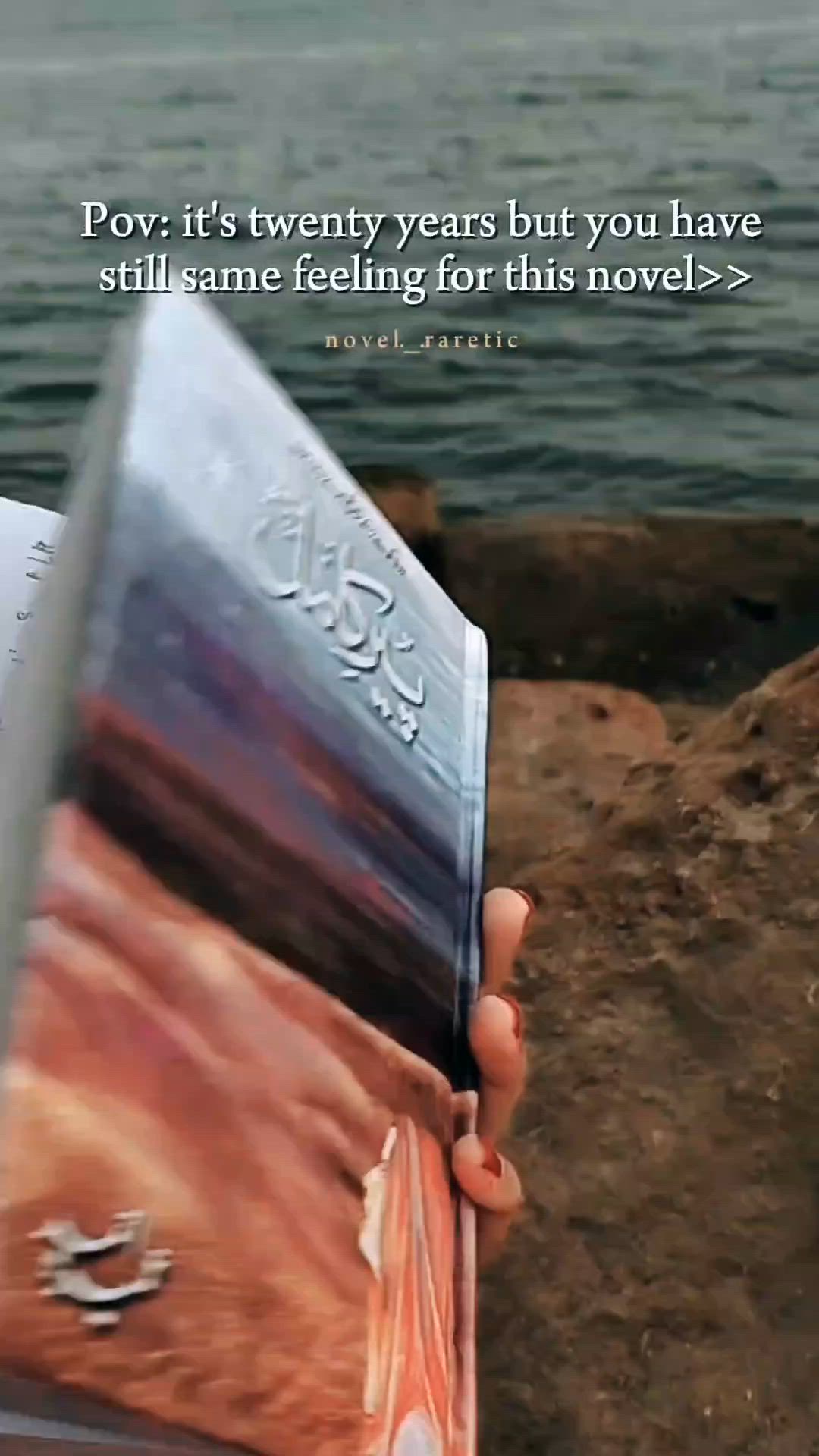 This may contain: someone is holding up a book in front of the water with a quote on it