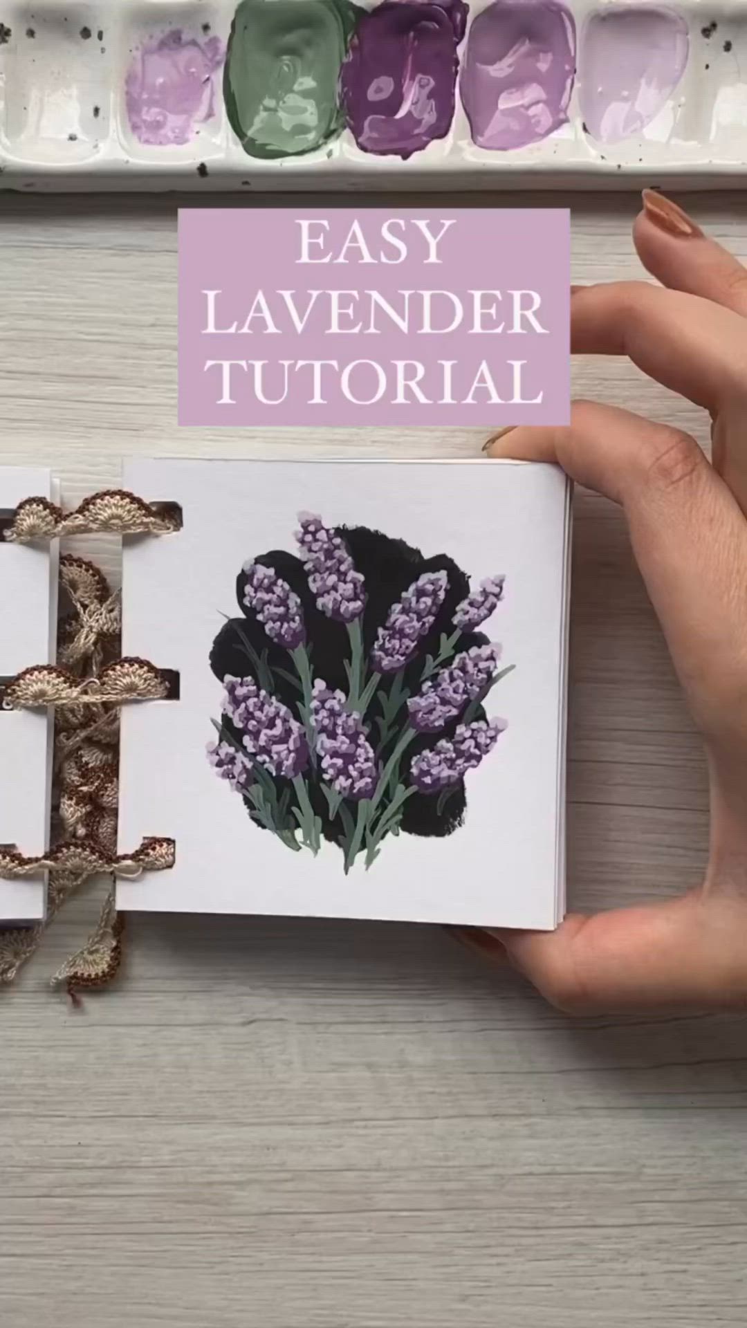 This may contain: a hand holding an open book with flowers on it and the title easy lavender journal