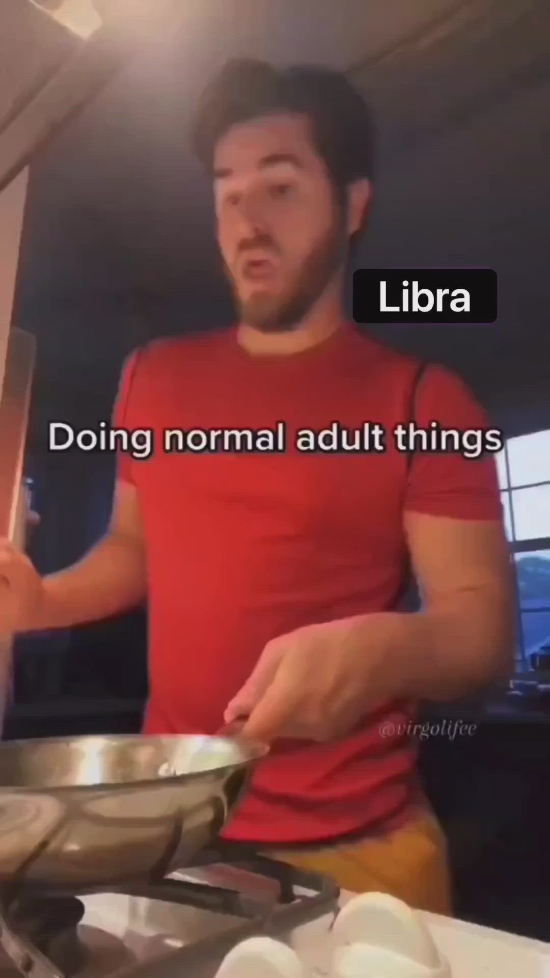 This may contain: a man standing in front of a stove holding a frying pan with the words libra on it