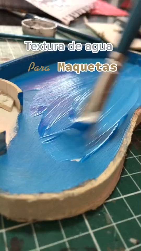 This may contain: a guitar being painted with blue paint on the top and bottom, next to a pair of scissors