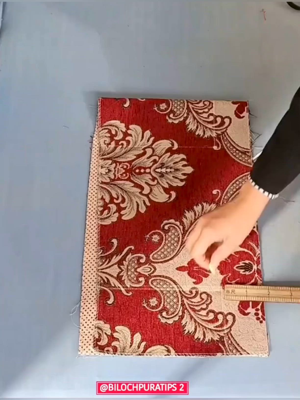 This may contain: a person is cutting up a red and white rug with a ruler on the floor