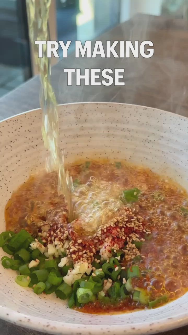 This may contain: a white bowl filled with soup sitting on top of a table