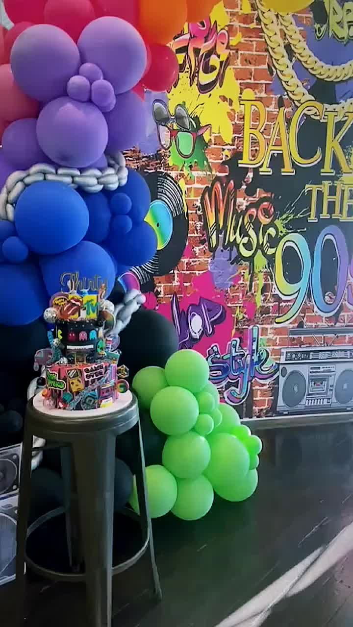 This may contain: there is a bunch of balloons on the table in front of the wall and chair