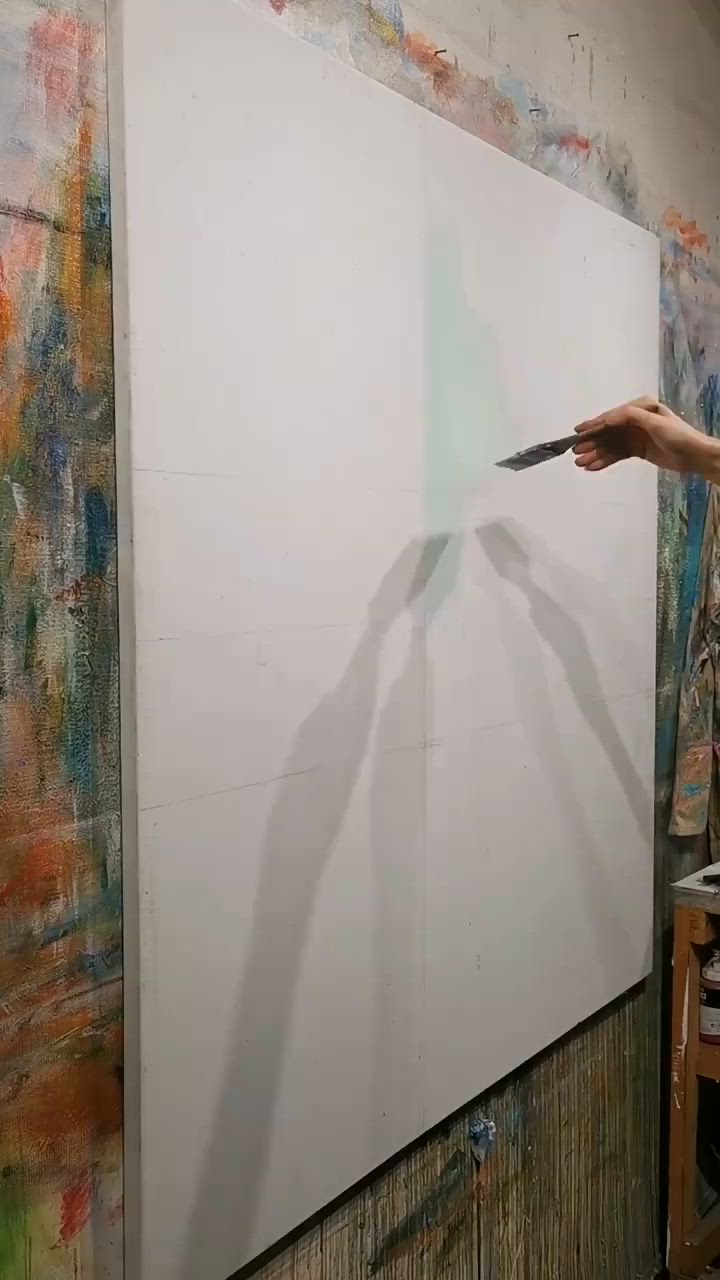 This may contain: a woman is painting a cityscape on a wall with paint rollers in her hand