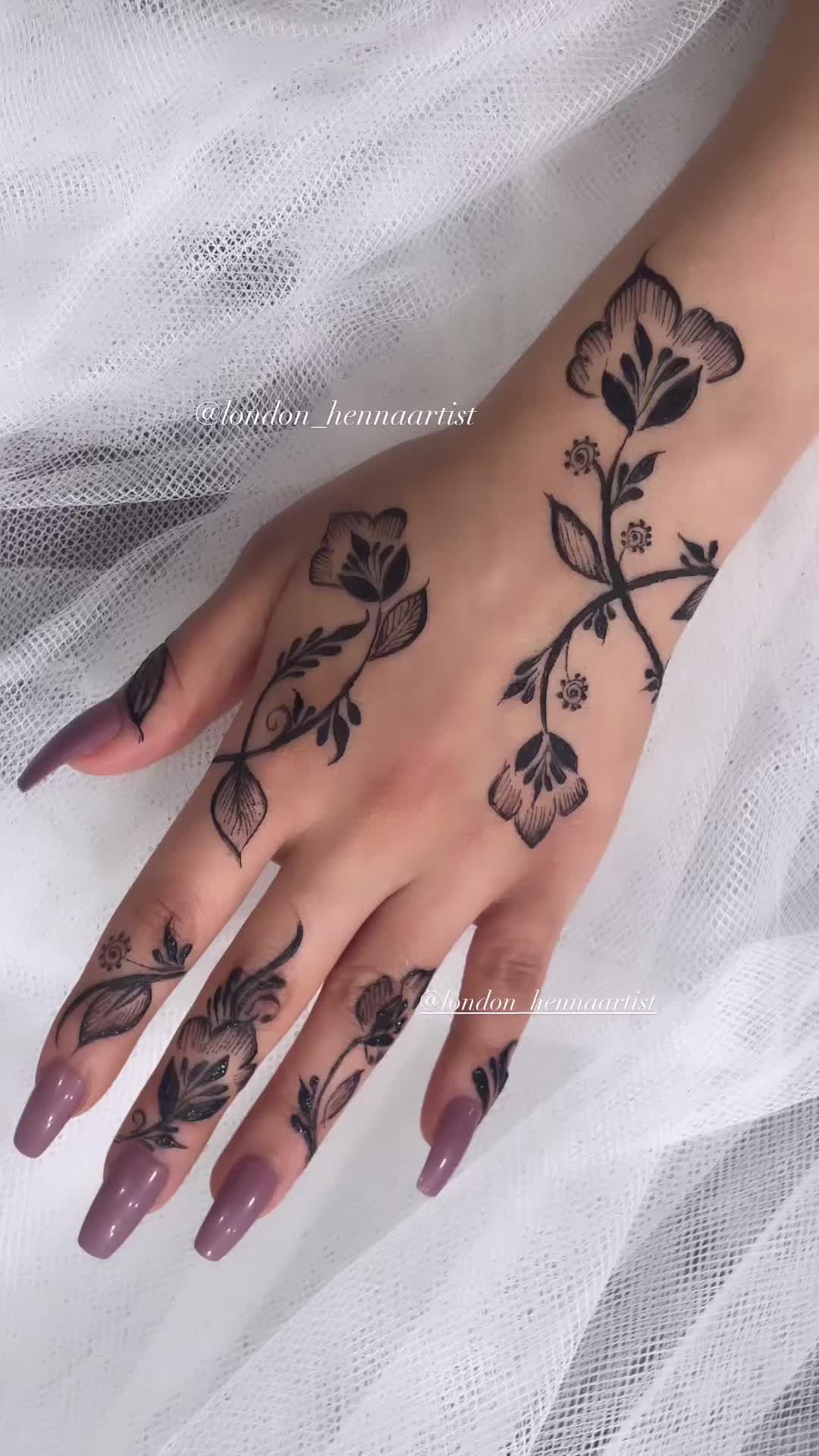 This may contain: a woman's hand with tattoos on it and flowers on the middle of her arm