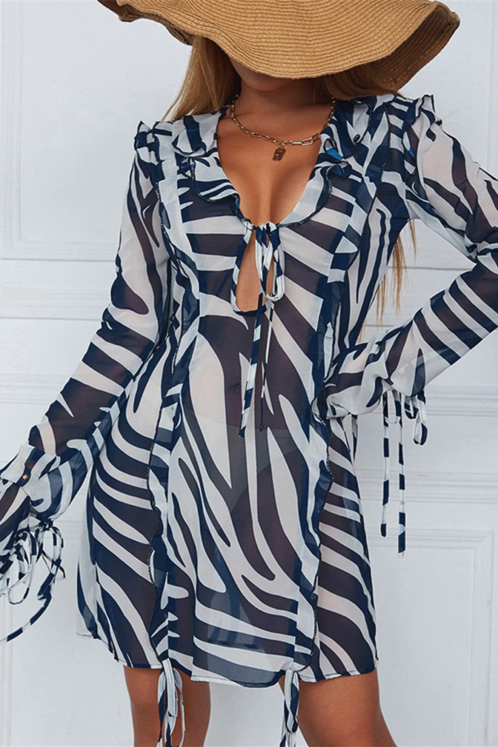 This contains: Stay stylish and comfortable as you enjoy the summer sun with our Long Sleeve Hollow Out Sundress. Made with a sexy V neck and ruffled details, this dress is perfect for any beach or party outing. The striped design adds a touch of fun and the mini length keeps you cool.