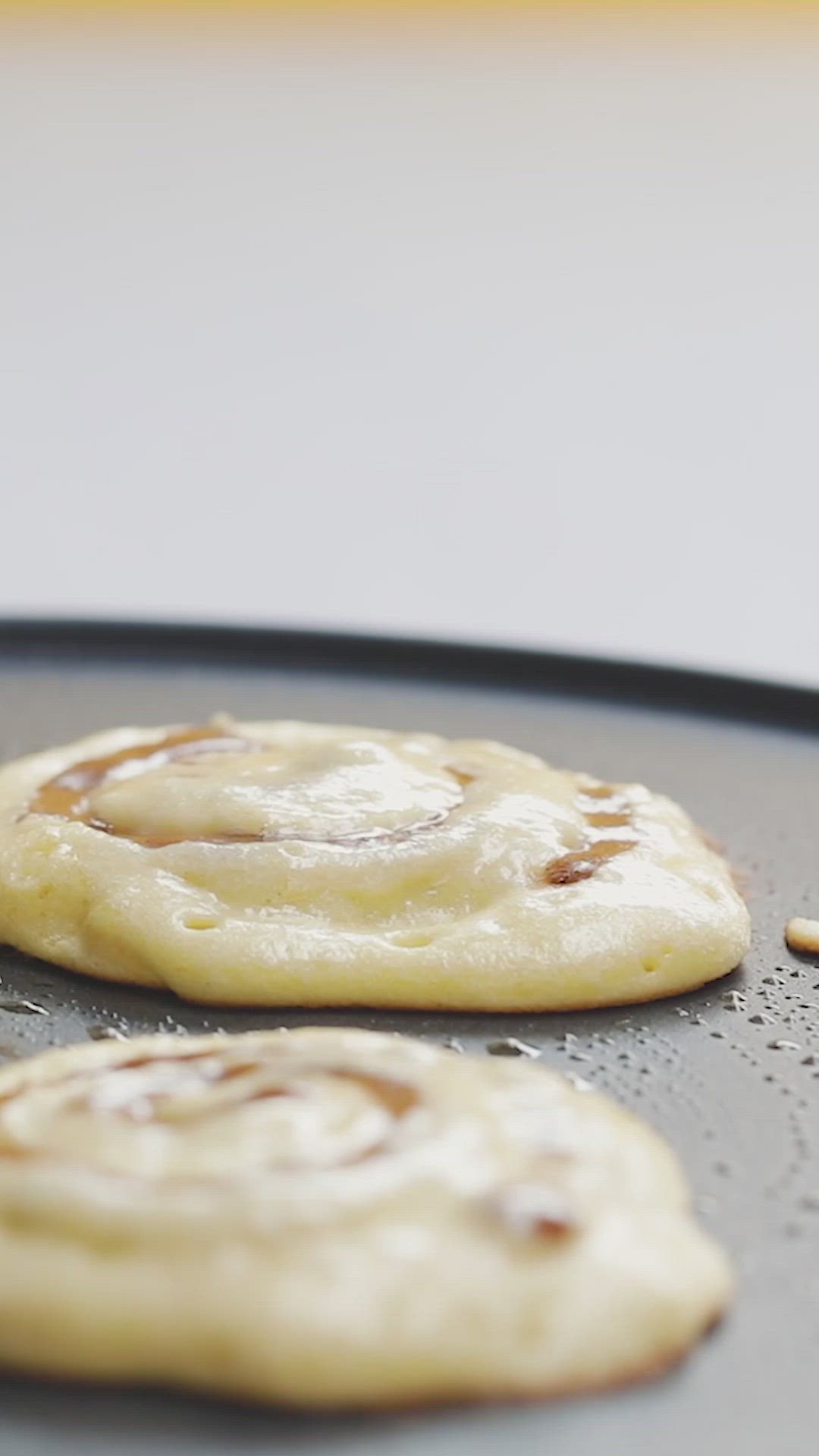 This may contain: cinnamon swirl pancakes on a white plate with orange slices