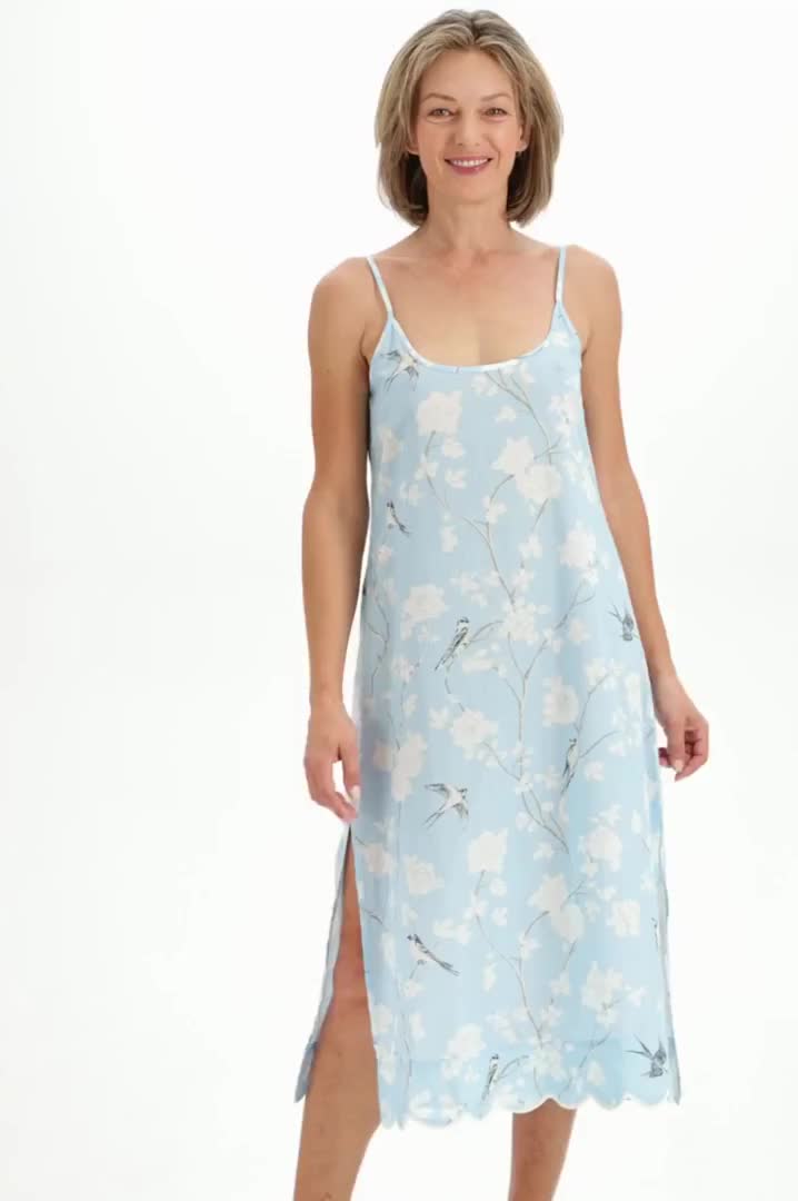 Always in style, Heidi's classic slip nightgown promises a peaceful sleep draped in super soft, lightweight cotton. The subtly feminine silhouette with flowing skirt and fitted bust offers an alluring alternative to traditional shift nightgowns, while a contrasting scalloped hem adds a sophisticated finish you won't find in everyday sleepwear. Offered here in a hand-painted pale blue gardenia print, this night-to-day essential brings you firmly into the now with a hint of Old World glamor. Slip 