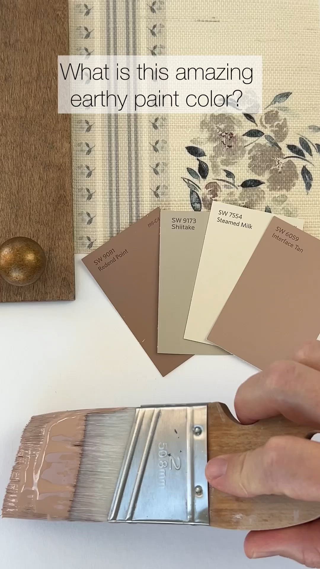 This may contain: a person holding a paint brush over some samples of paint on a table with the words what is this amazing earthy paint color?