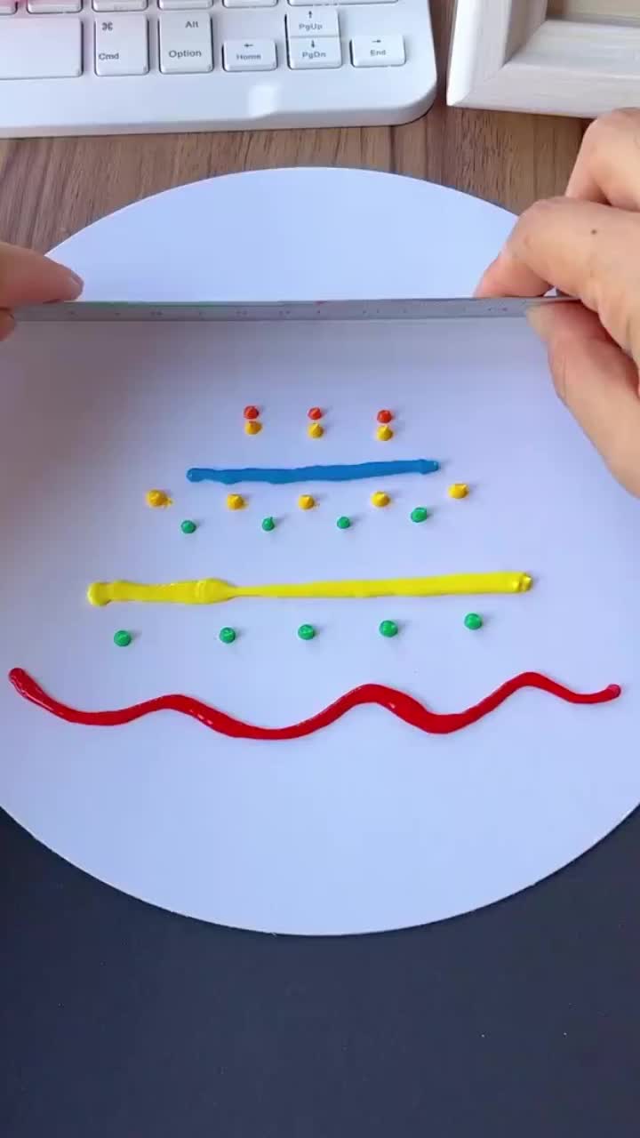 This may contain: two hands are using scissors to make a paper craft with colored pencils on a white plate