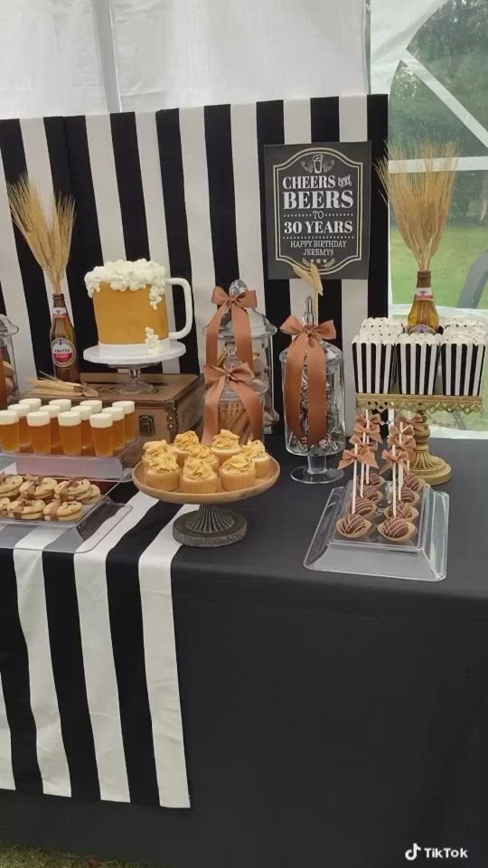 This may contain: an assortment of desserts and pastries displayed on a table with black and white stripes