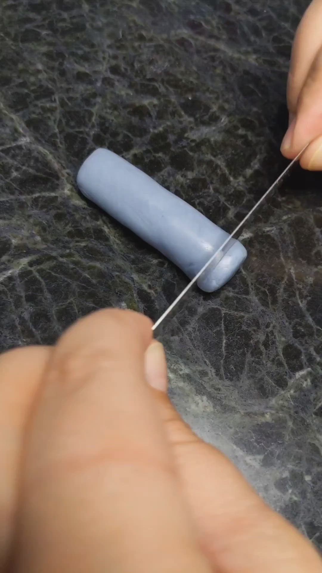 This may contain: a person is using a needle to thread something on a table with black marble counter top