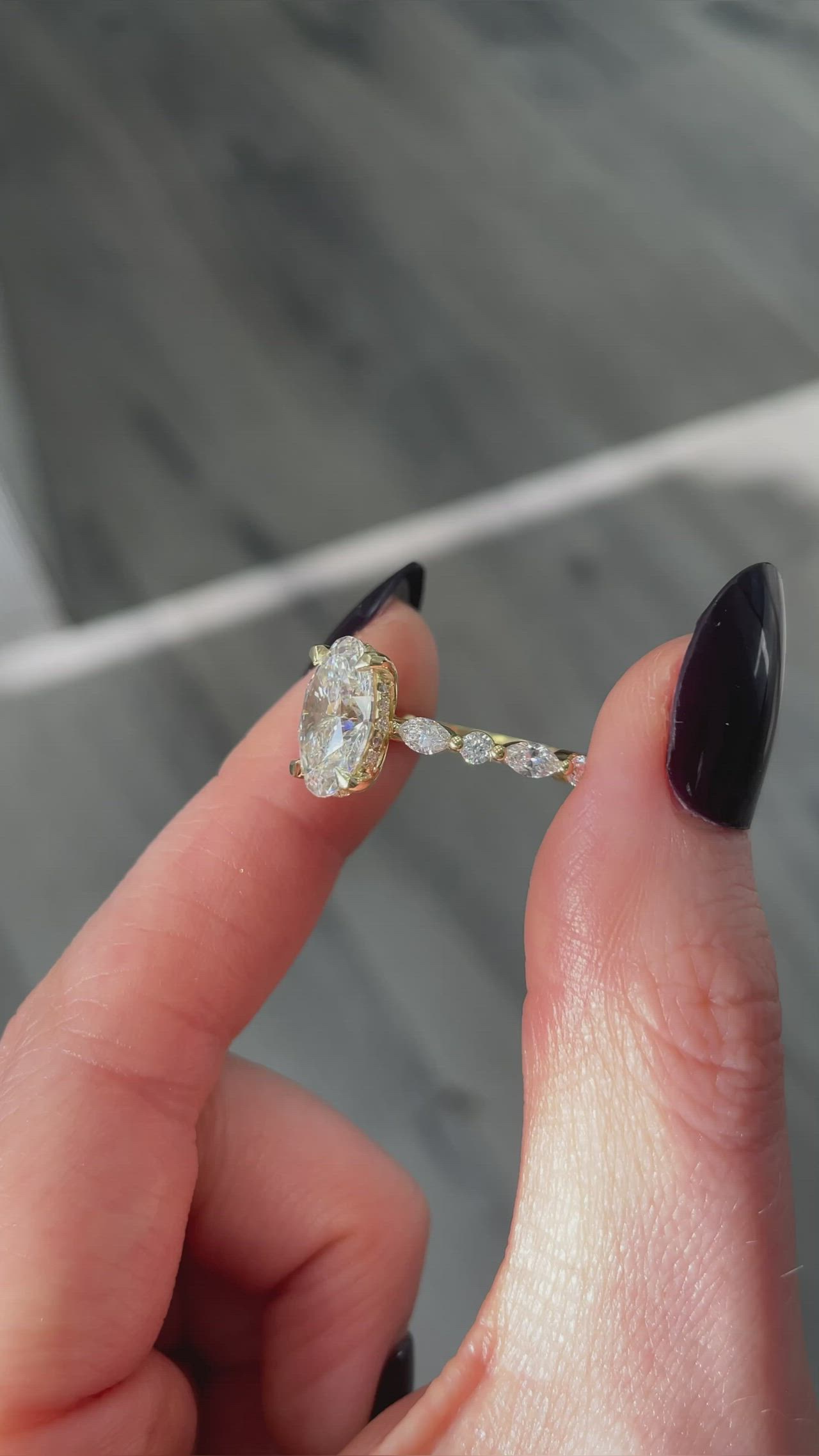 This may contain: a woman's hand holding an engagement ring with two diamonds on the top and bottom