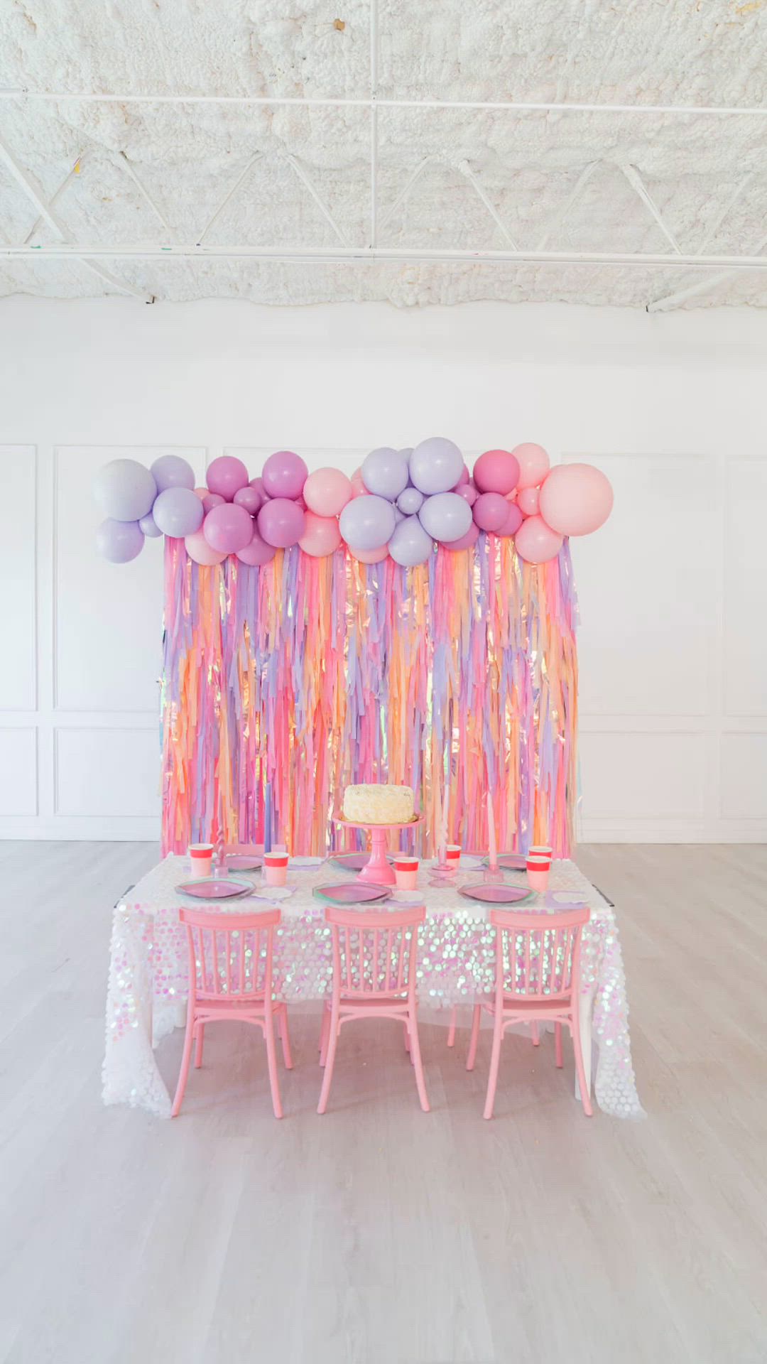 This may contain: a table topped with pink and purple balloons