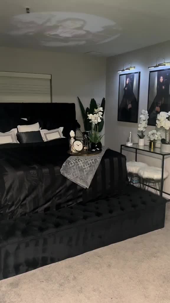 This may contain: a black and white bedroom with pictures on the wall