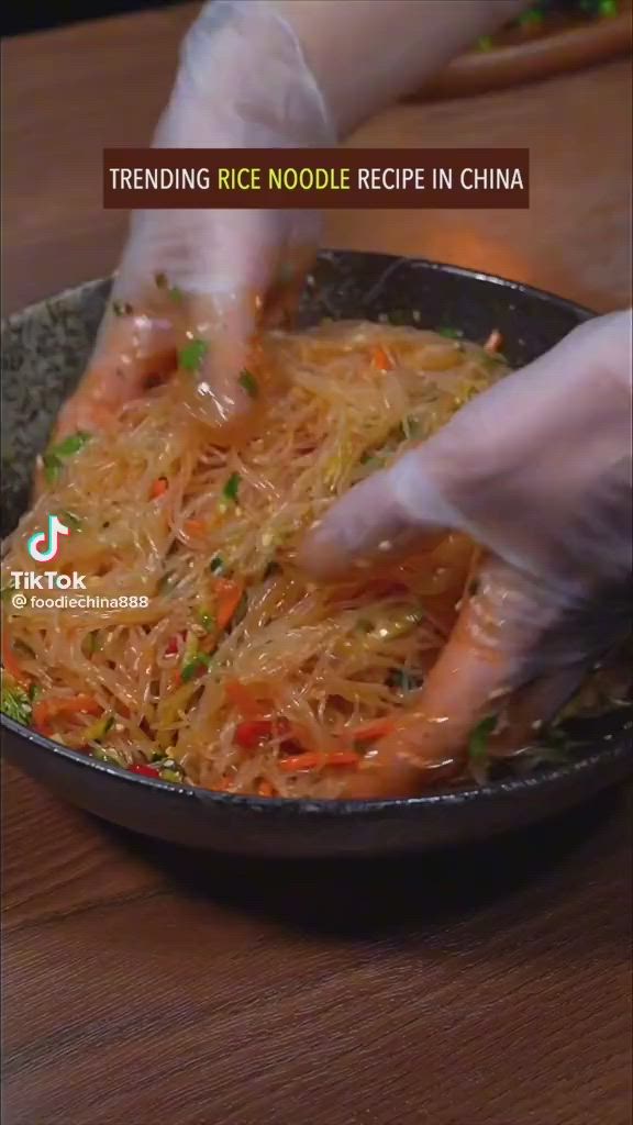 This may contain: someone is cooking food in a skillet on the table with words describing how to make rice noodles