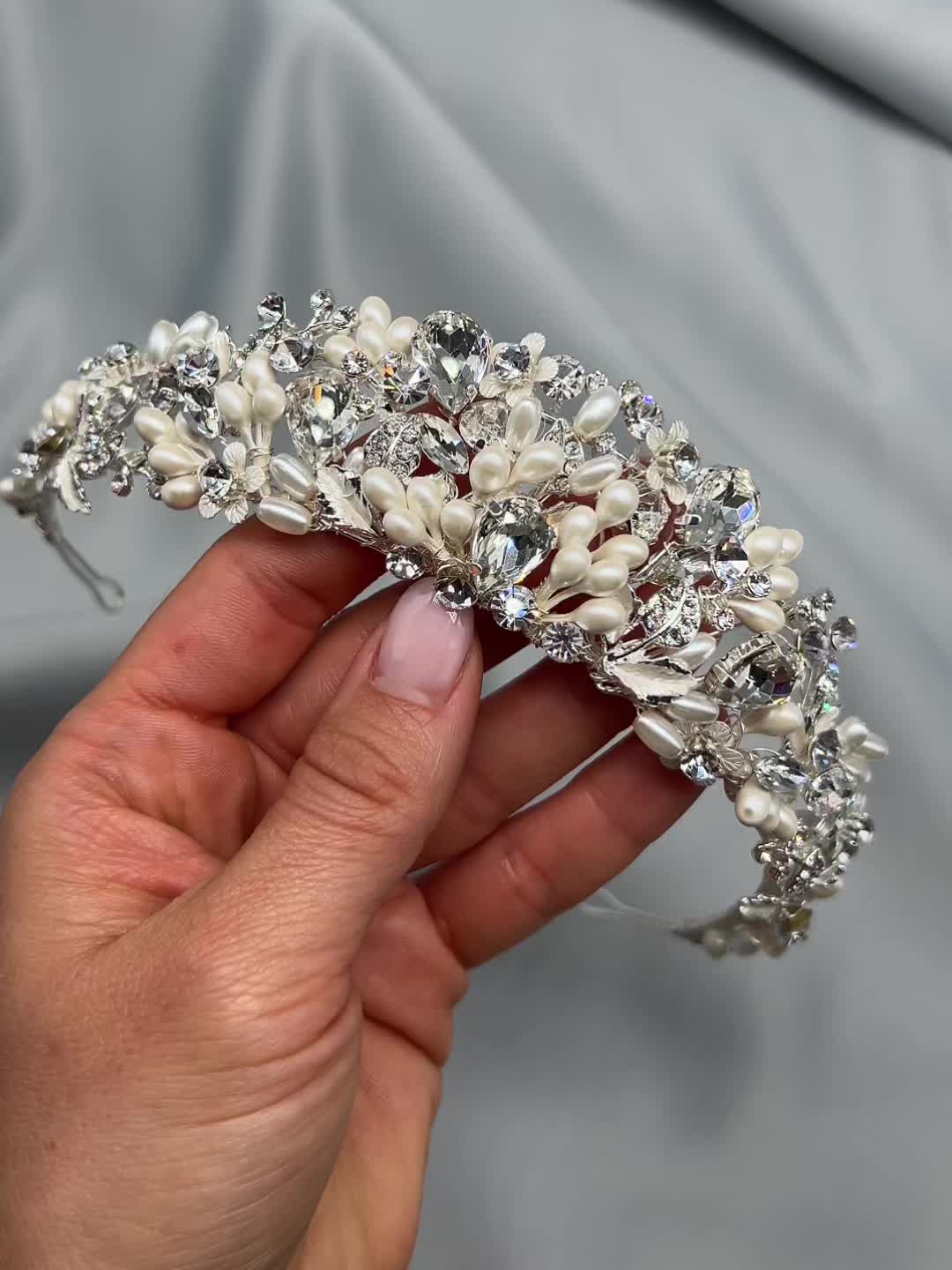 AS SEEN ON Featured on Love is Blind Season 6! Feel like a princess as you walk down the aisle in our Audra Pearl & Crystal Tiara. With hand wired pearl clusters, delicate florals & crystals that shimmer from all angles, this headpiece is perfect for your grand entrance. Designed with simulated pearl clusters and crystal gemstones. Measures 1.5 inches at center peak. Pin loops are located at each end so you can secure in your hair with bobby pins, if needed. Style #3391 Photo Credit: Fig Tree Pi