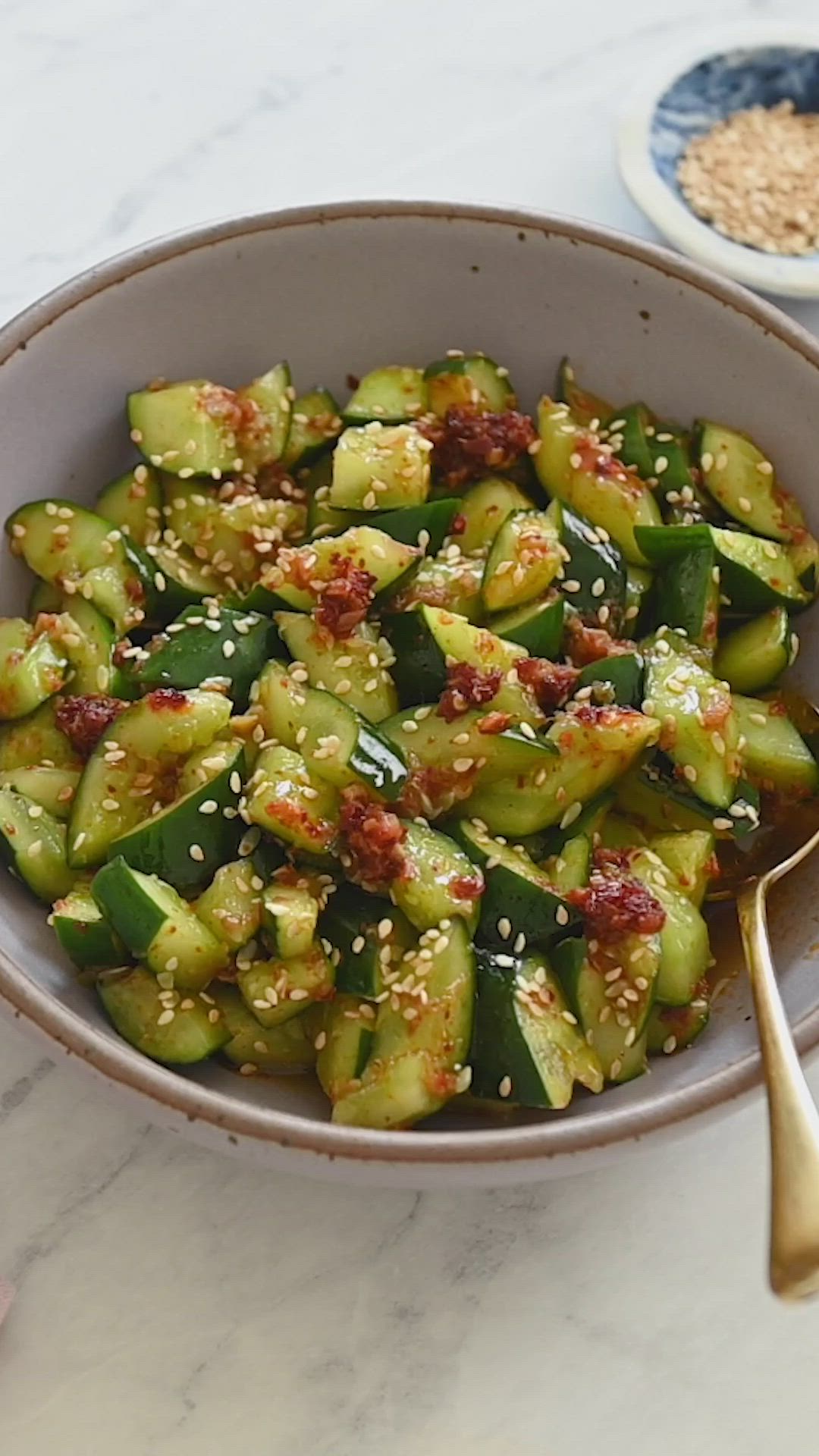 This may contain: a bowl filled with cucumber salad on top of a table