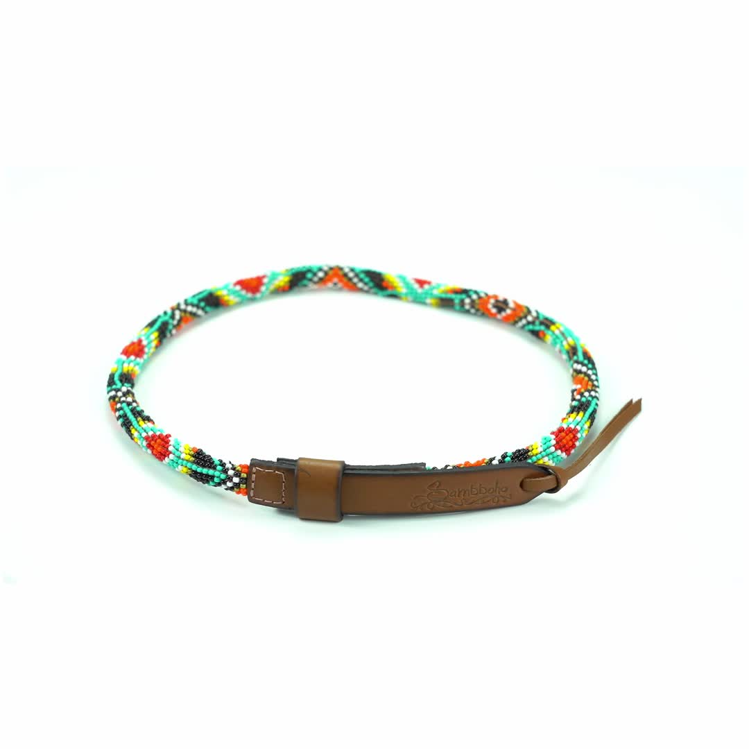 This may contain: a brown leather bracelet with multicolored braiding