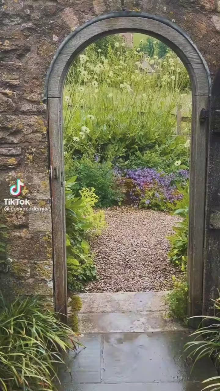 This may contain: a woman is walking down the street with an umbrella over her head and there is a sign that says welcome to the english country side