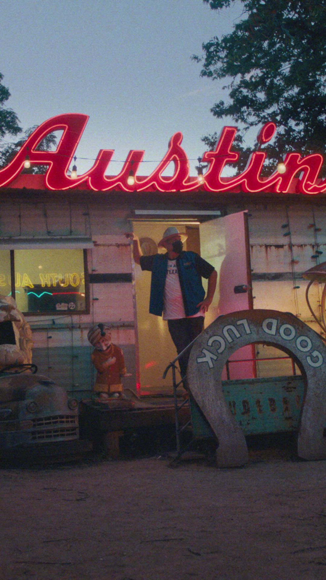 This may contain: a man standing in the doorway of a mobile home that has an advertising sign on it