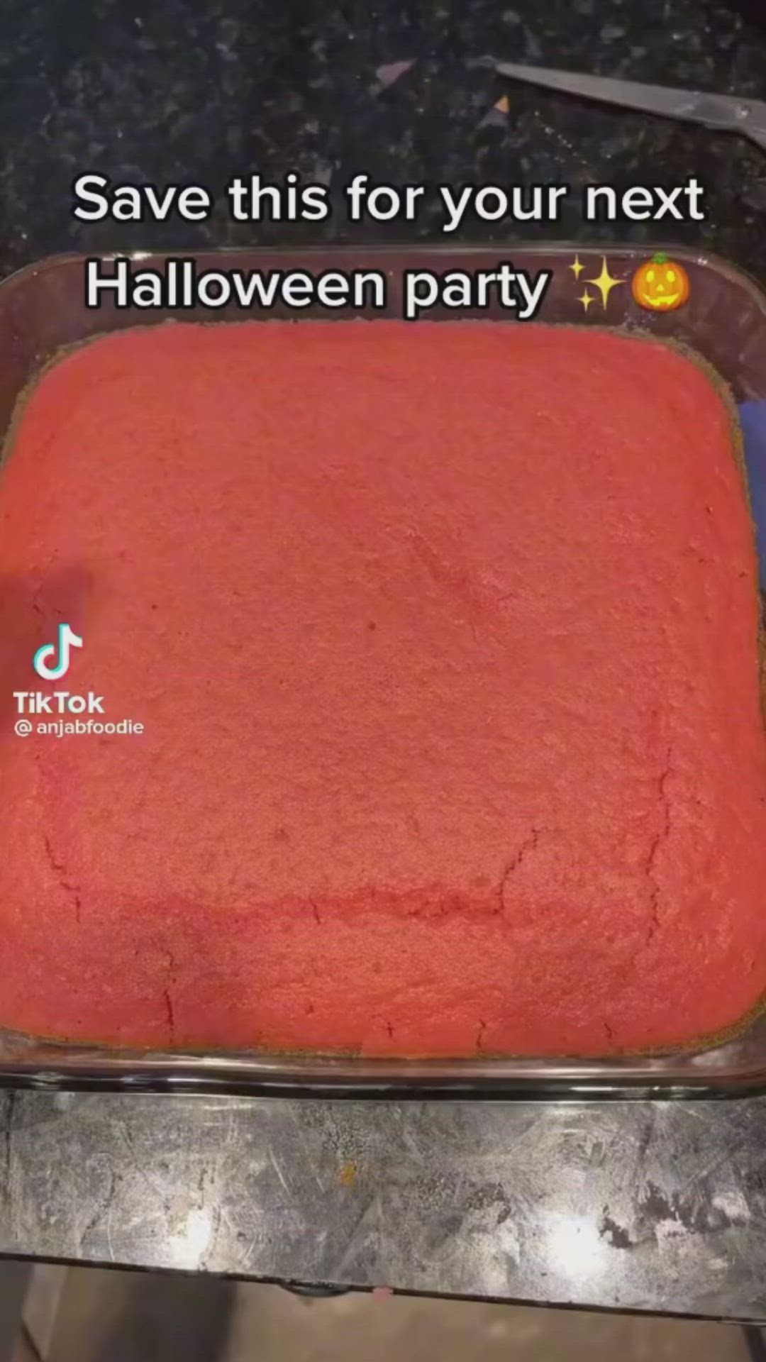 This may contain: a red cake sitting on top of a metal pan