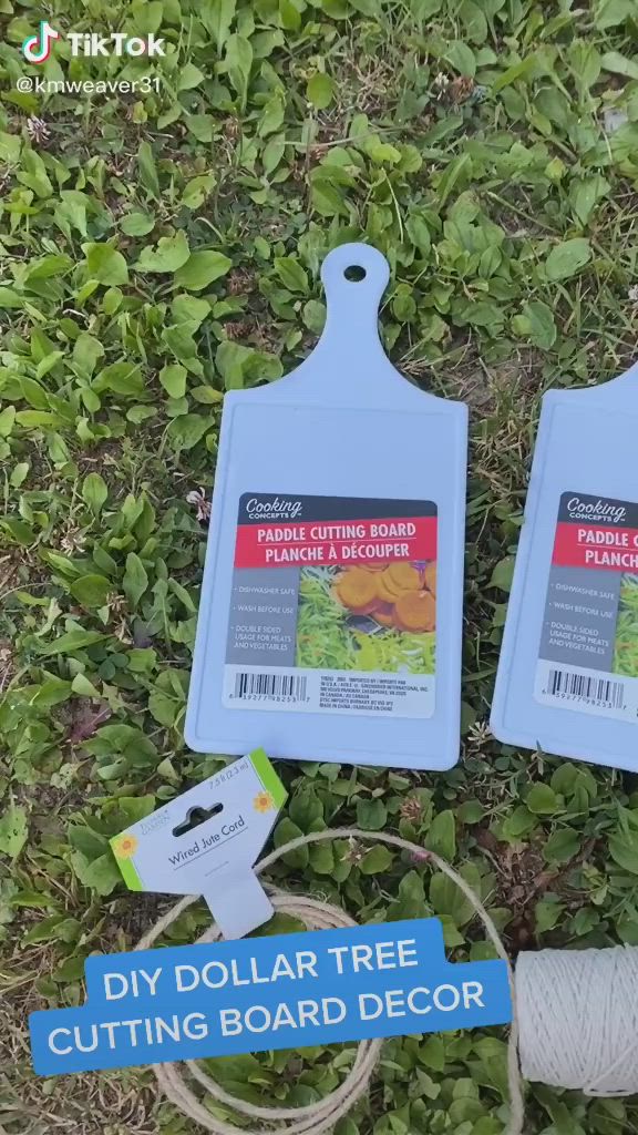 This may contain: two plastic cutting boards sitting on top of grass next to a spool of string