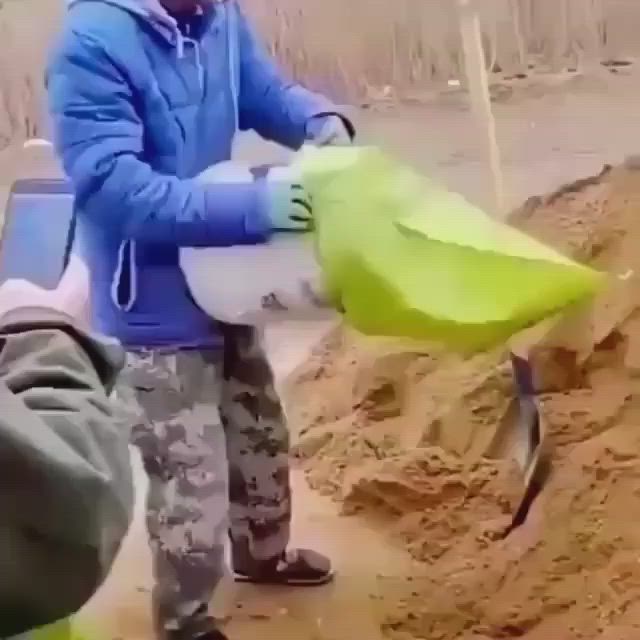 This may contain: two young boys standing next to each other with buckets on their feet and one holding a knife