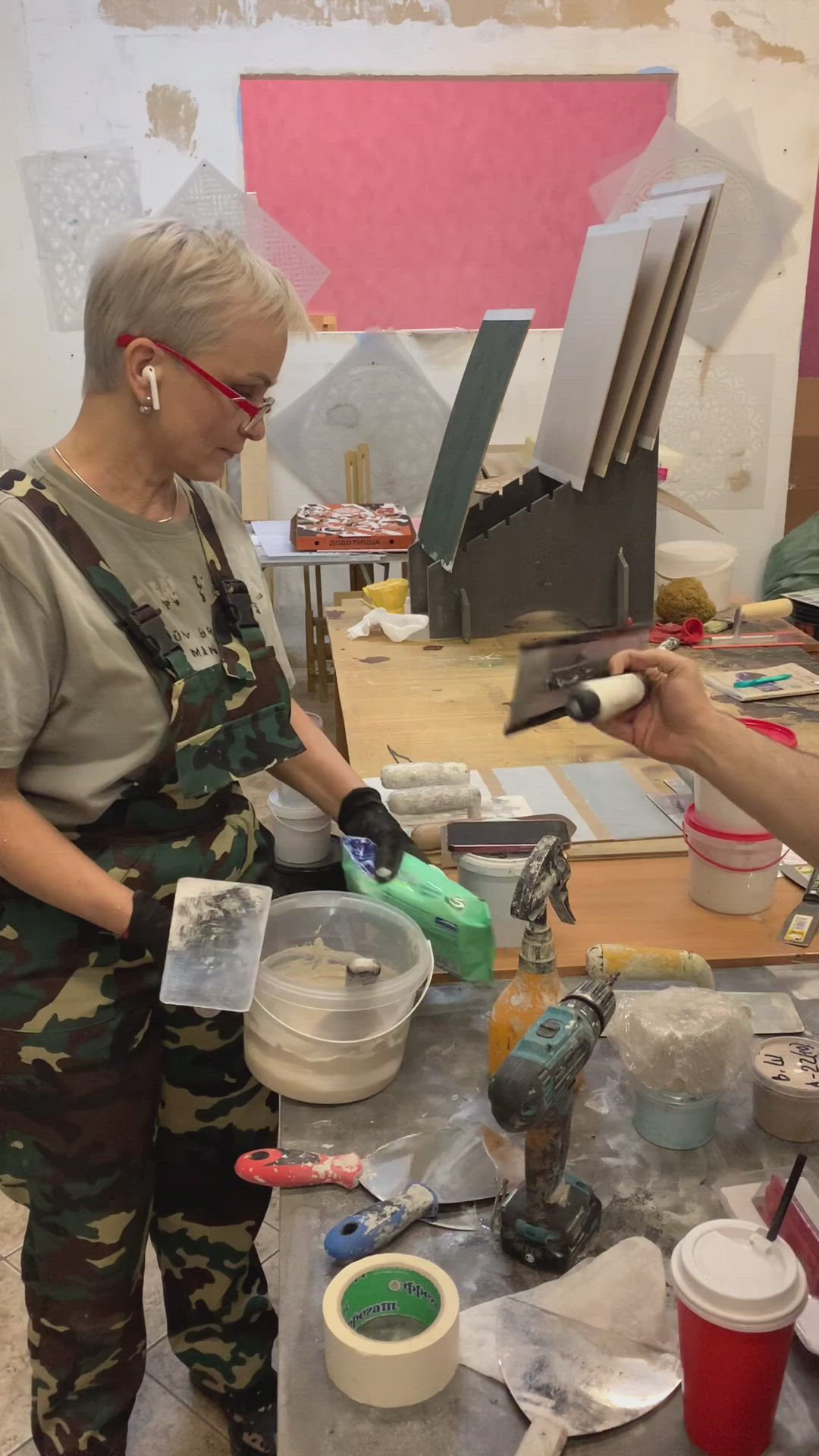 This may contain: an older woman is painting in her studio