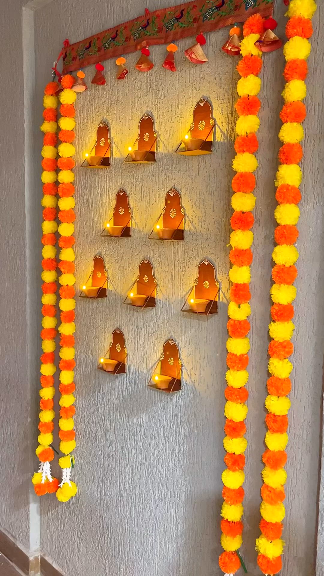 This may contain: a wall decorated with candles and garlands for diwaling on the eve of diwaling