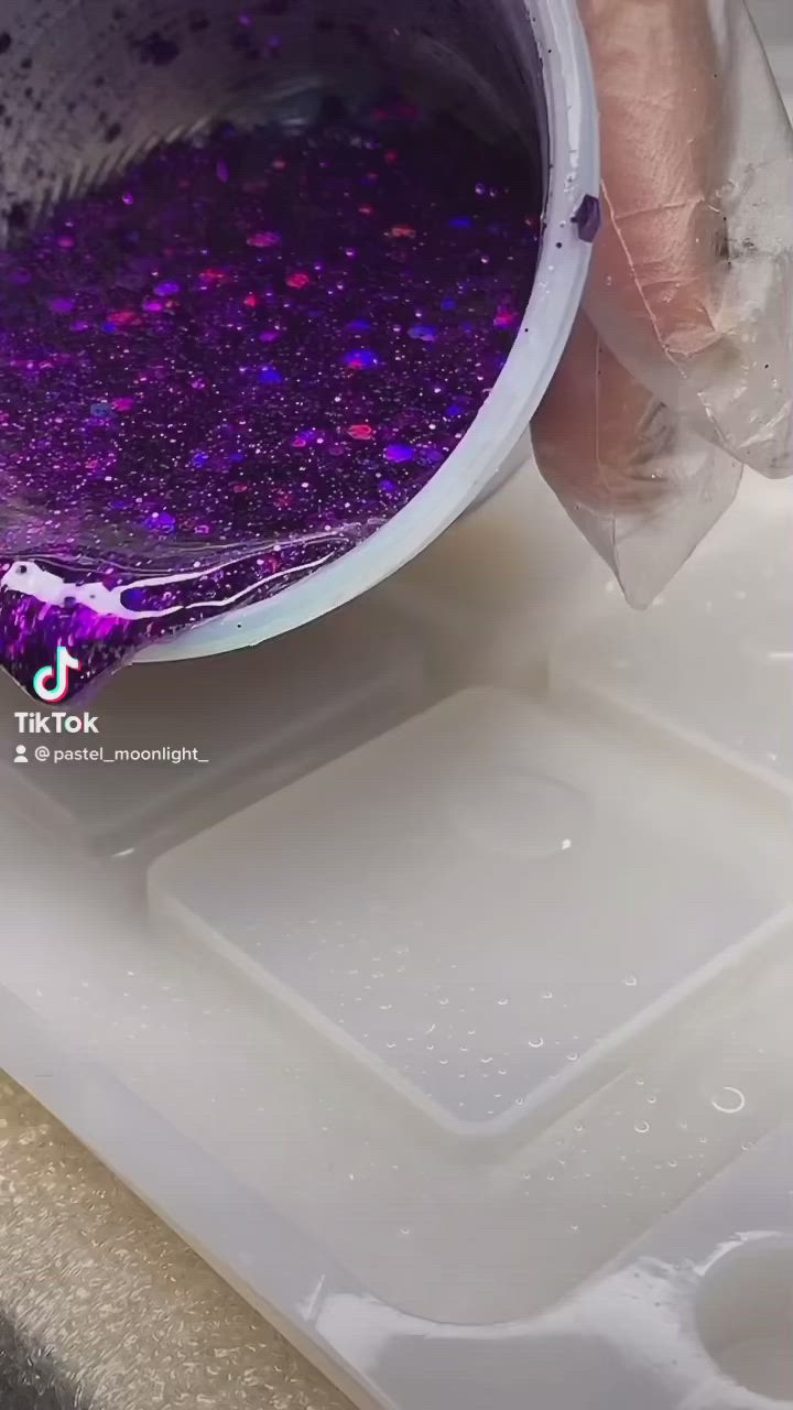 This may contain: a person is pouring purple liquid into a container