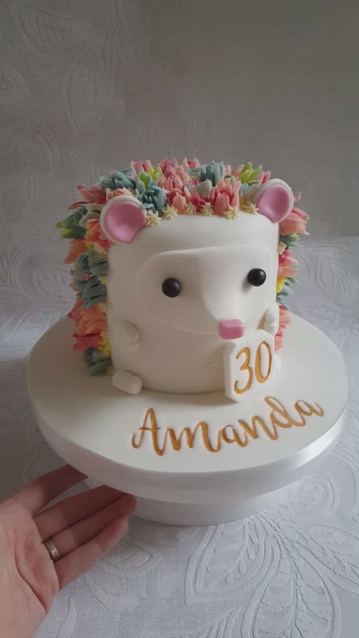 This may contain: a white cake with an animal on it and the number 30 is decorated in flowers